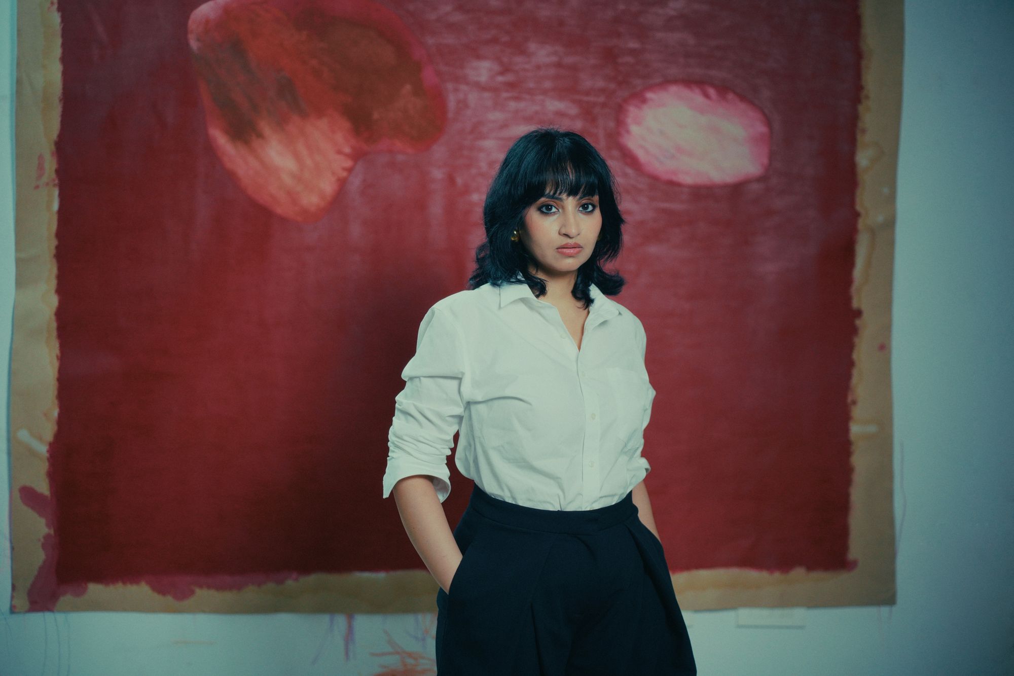 Sandhya Chawla in her studio with a large red painting