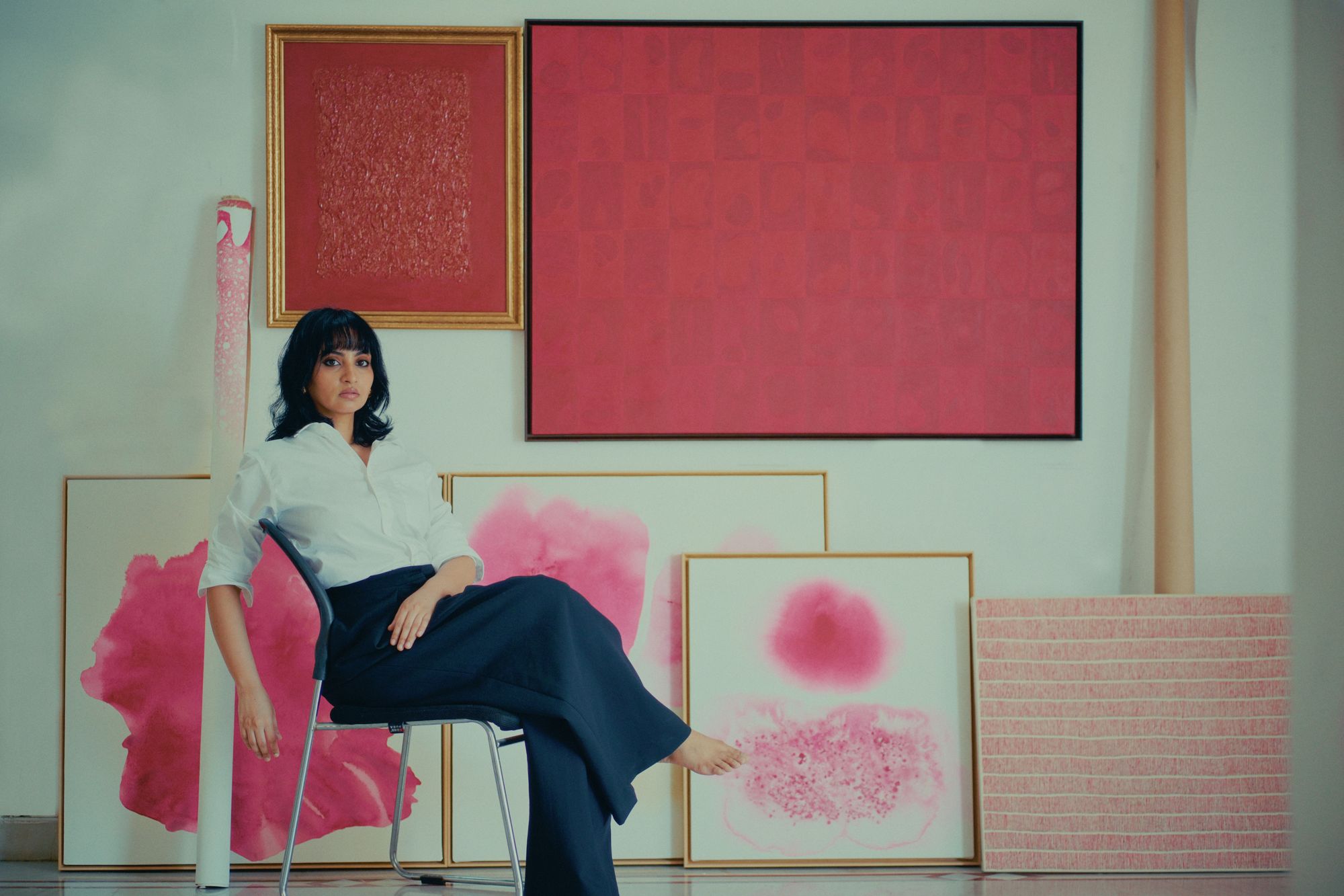 Sandhya Chawla seated in her studio among her paintings